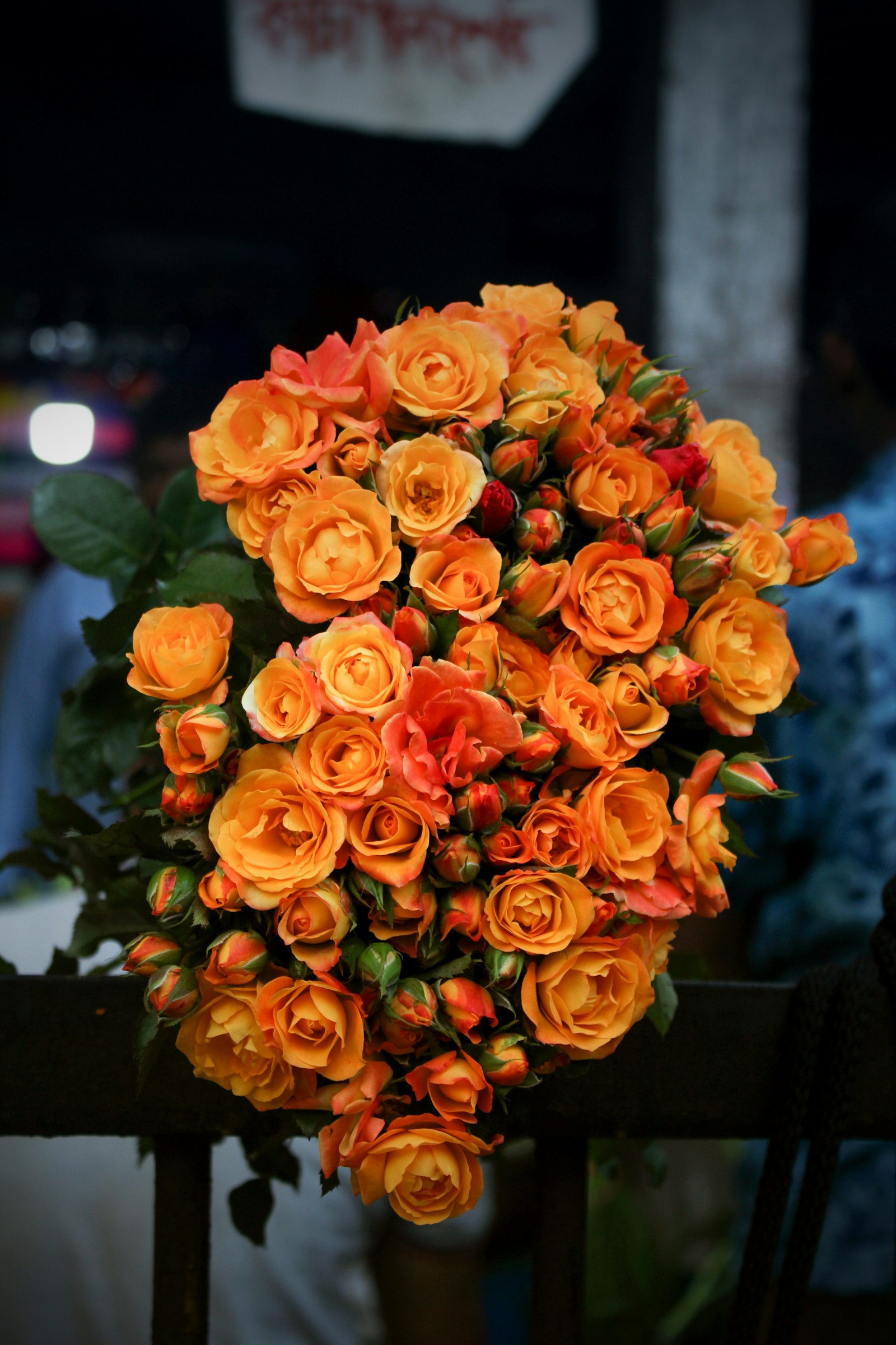 Orange roses and greenery arranged on a table